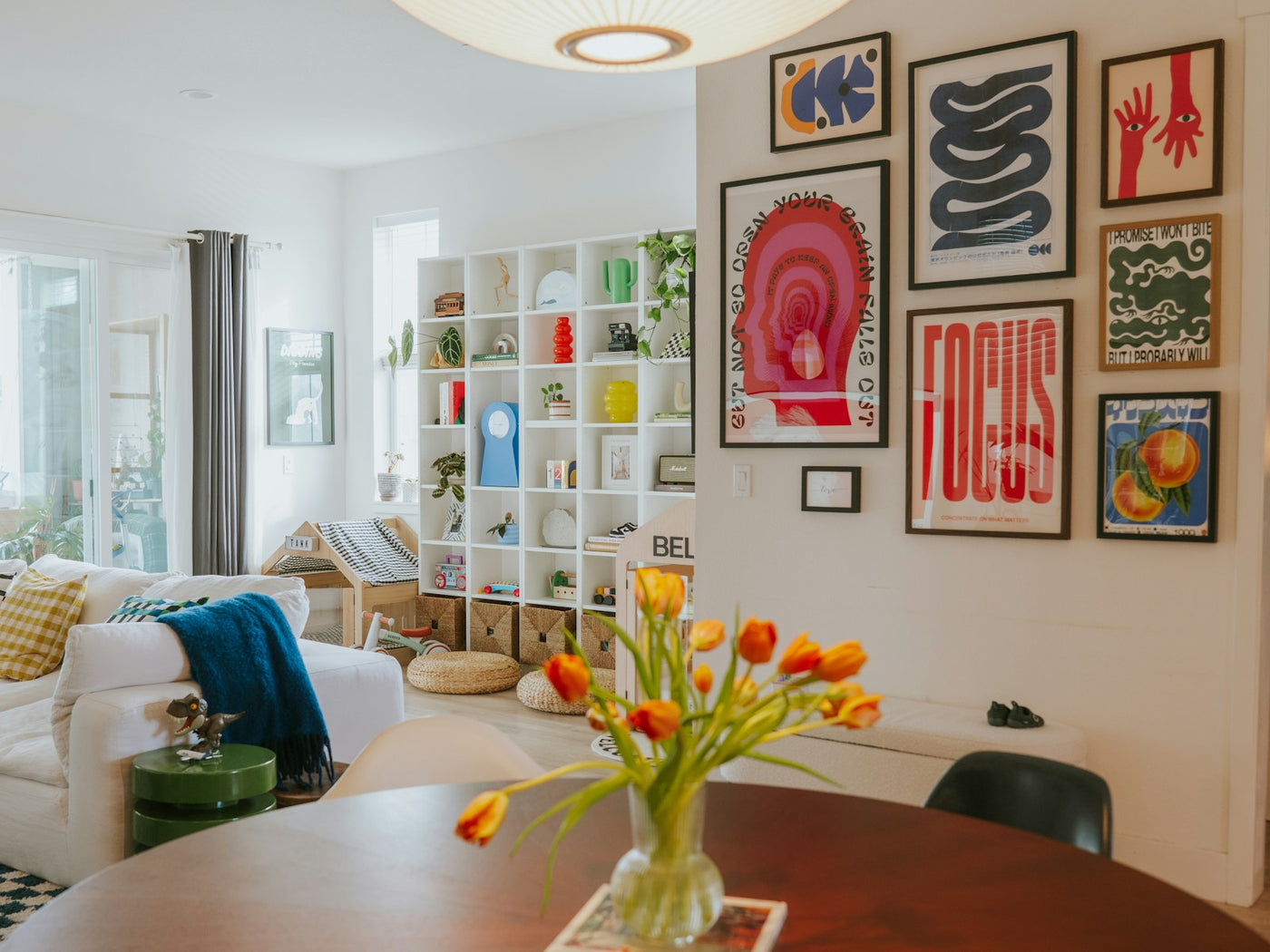 Bright living room with a colourful gallery wall above a bench